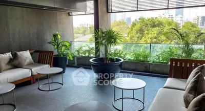 Stylish balcony with modern seating and lush greenery offering a serene city view.