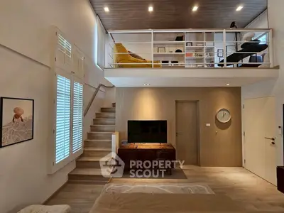 Modern loft-style living room with mezzanine, stylish decor, and natural light.