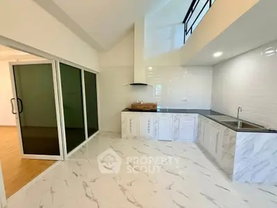 Spacious modern kitchen with marble flooring and sleek cabinetry in open layout design.
