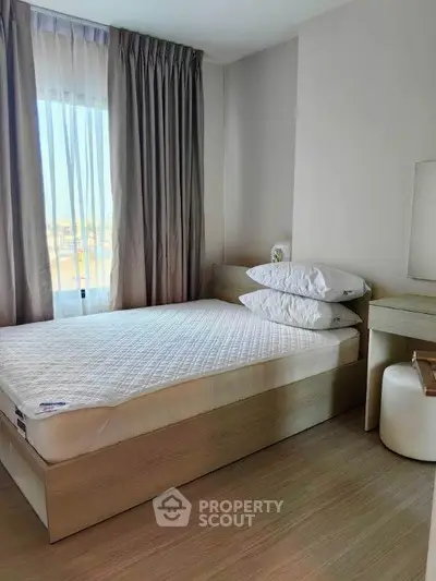 Cozy bedroom with natural light and modern furnishings, perfect for relaxation and comfort.
