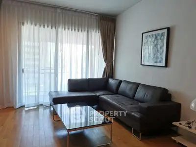 Modern living room with sleek leather sofa and glass coffee table, featuring floor-to-ceiling windows and elegant curtains.