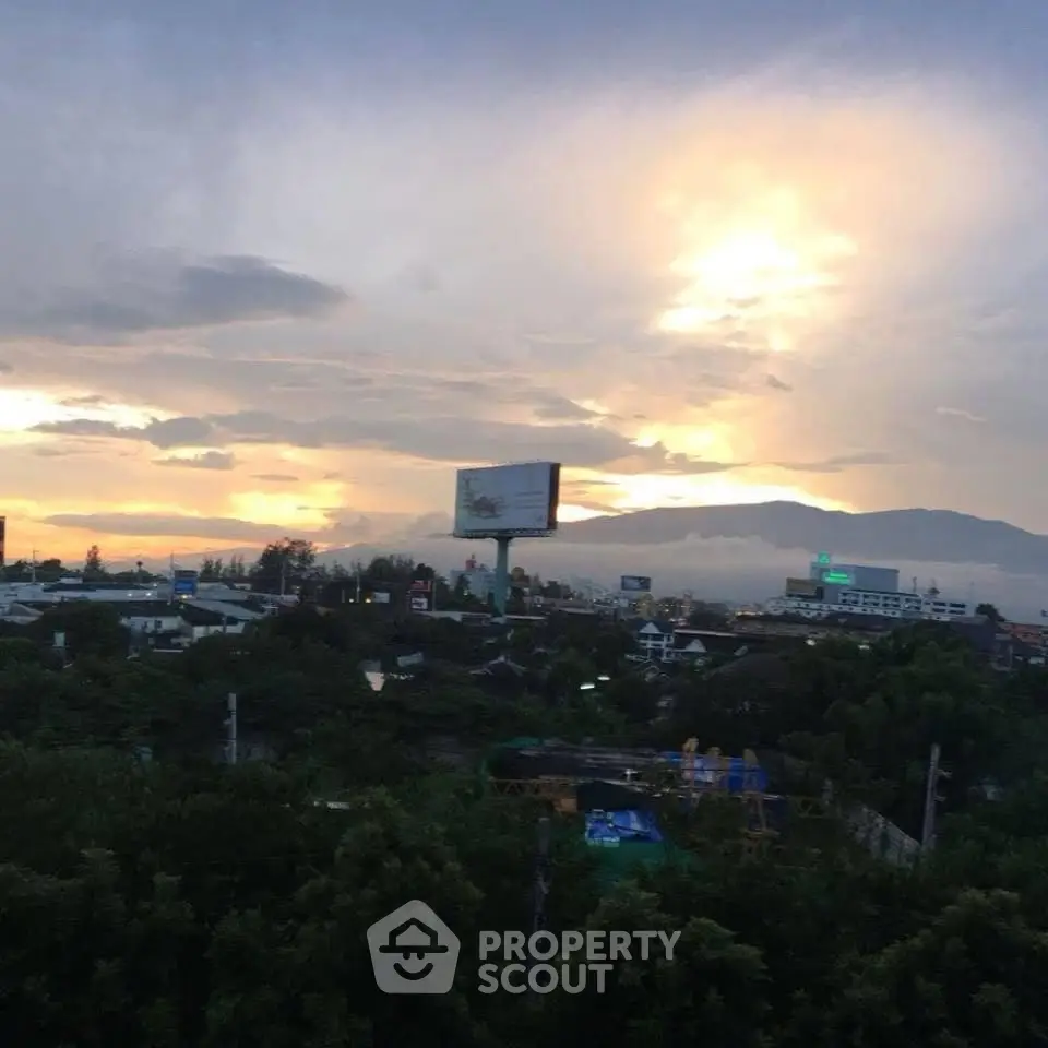 Stunning sunset view over a cityscape with mountains in the background, perfect for urban living.