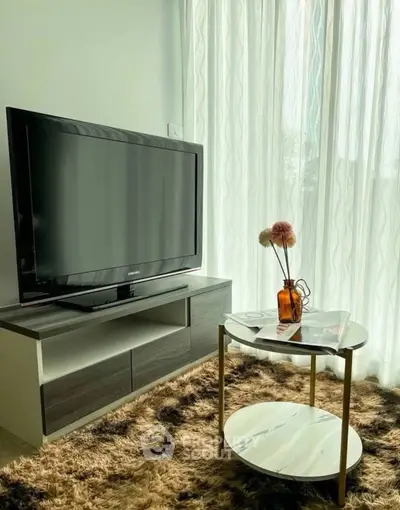 Modern living room with stylish TV stand and elegant coffee table, bathed in natural light from large windows.