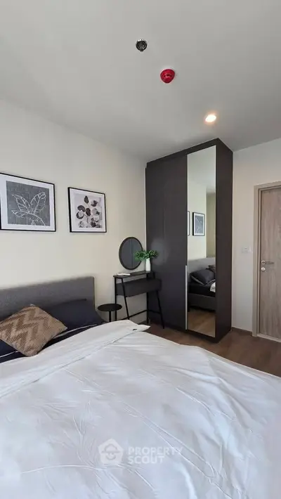 Modern bedroom with stylish decor, featuring a cozy bed, sleek wardrobe, and elegant wall art.