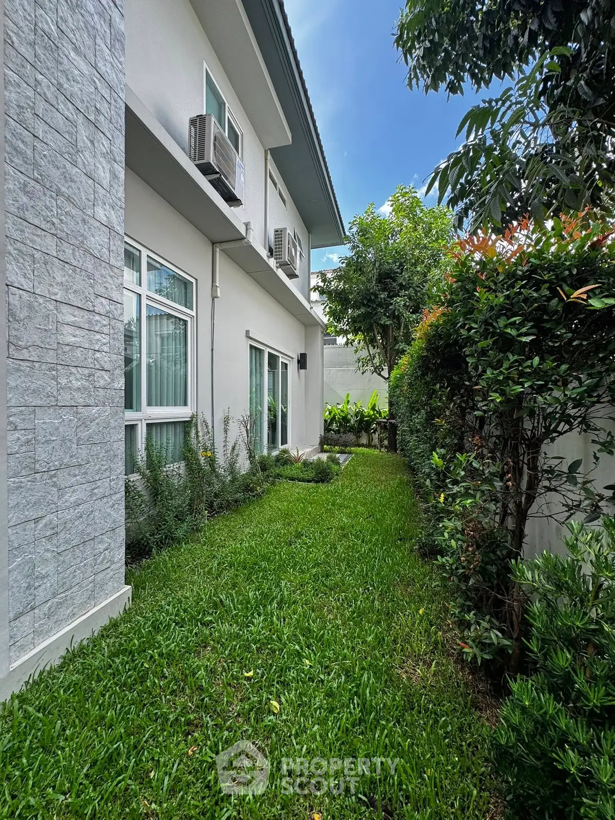 Charming residential garden with lush greenery and modern exterior, perfect for relaxation and outdoor enjoyment.
