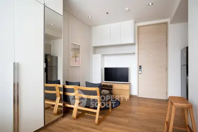 Modern living room with wooden flooring and sleek furniture in a stylish apartment.