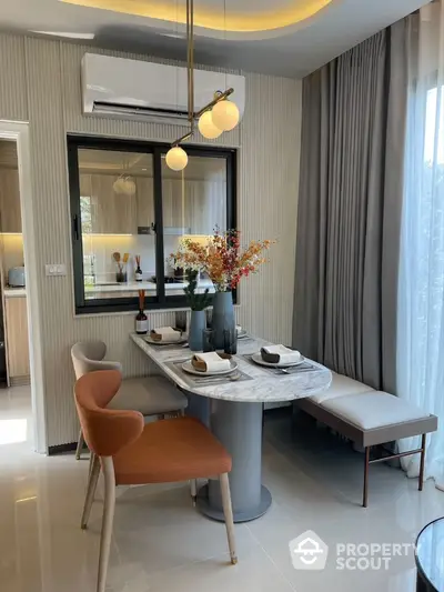 Modern dining area with elegant marble table and stylish chairs in a bright apartment.