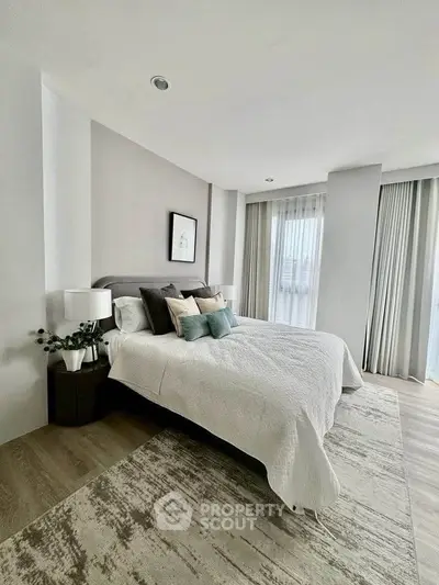 Elegant bedroom with modern decor and large windows offering natural light