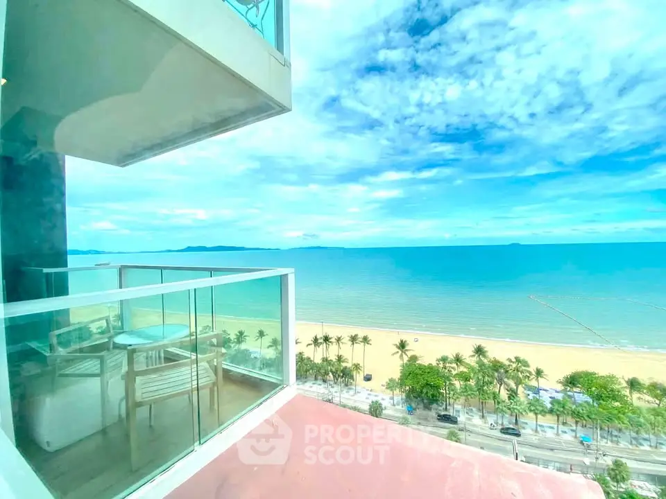 Stunning beachfront balcony with panoramic ocean views and modern glass railing, perfect for relaxation.