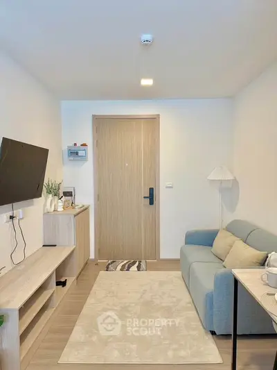 Modern living room with cozy sofa and wall-mounted TV in a stylish apartment.
