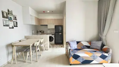 Modern open-plan living room and kitchen with stylish furniture and appliances