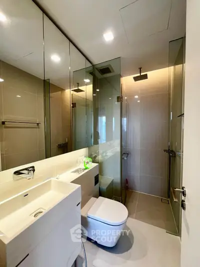 Modern bathroom with glass shower and sleek fixtures in a contemporary apartment.