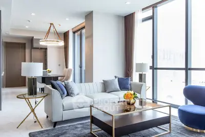 Luxurious modern living room with elegant decor and large windows offering abundant natural light.