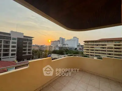 Spacious balcony with stunning city view at sunset, perfect for relaxation.
