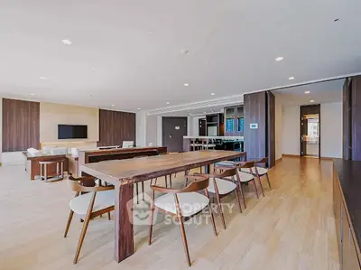 Spacious modern living room with elegant wooden dining table and open layout.