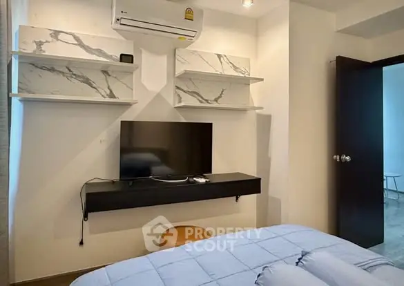 Modern bedroom with wall-mounted TV and air conditioning unit