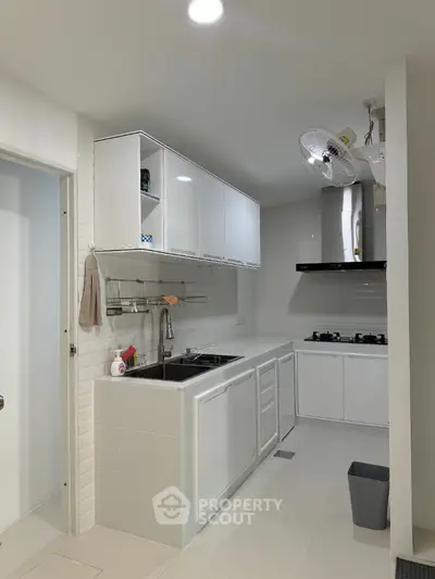 Modern white kitchen with sleek cabinetry and gas stove