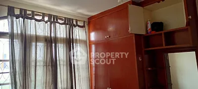 Spacious bedroom with large window and built-in wooden wardrobe