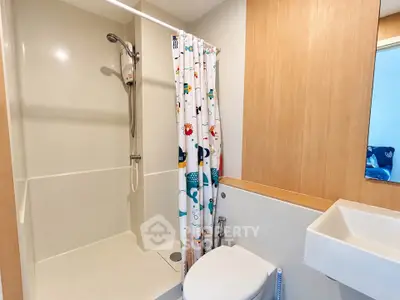 Modern bathroom with shower and colorful curtain in cozy apartment.
