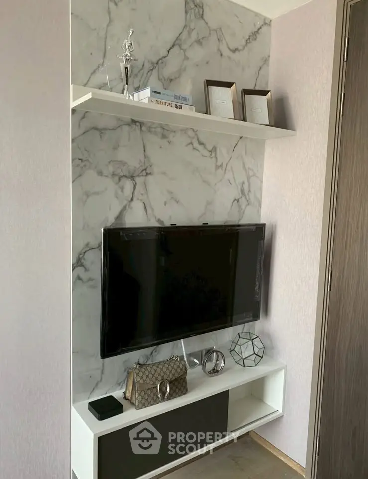 Stylish living room corner with marble accent wall and modern TV setup