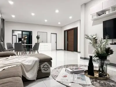 Spacious modern living room with elegant decor and open dining area, perfect for entertaining.