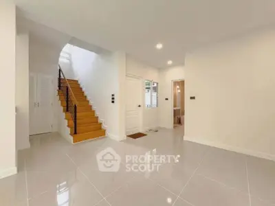 Spacious modern interior with elegant staircase and glossy tiled flooring
