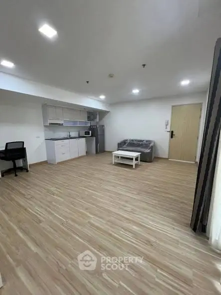 Spacious modern living room with open kitchen and sleek wooden flooring