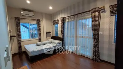 Spacious bedroom with elegant curtains and wooden flooring