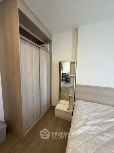 Modern bedroom with wooden wardrobe and cozy bed in stylish apartment