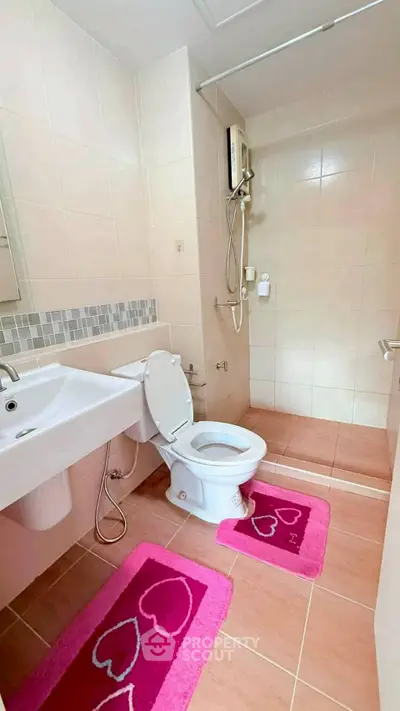 Charming bathroom with modern fixtures and pink heart-themed decor, perfect for a cozy home.