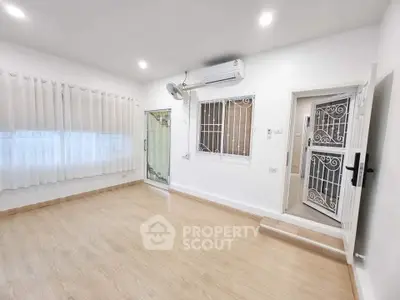 Bright and airy room with wooden flooring and air conditioning, ideal for versatile living space.