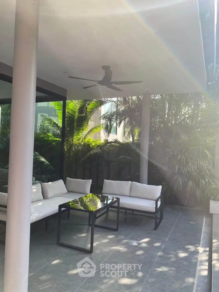 Luxurious outdoor patio with modern furniture and lush greenery