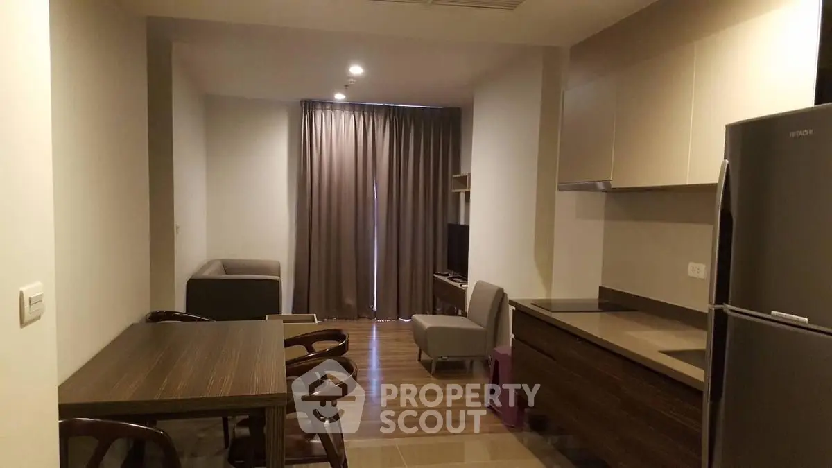 Modern open-plan living room with dining area and kitchen in stylish apartment.