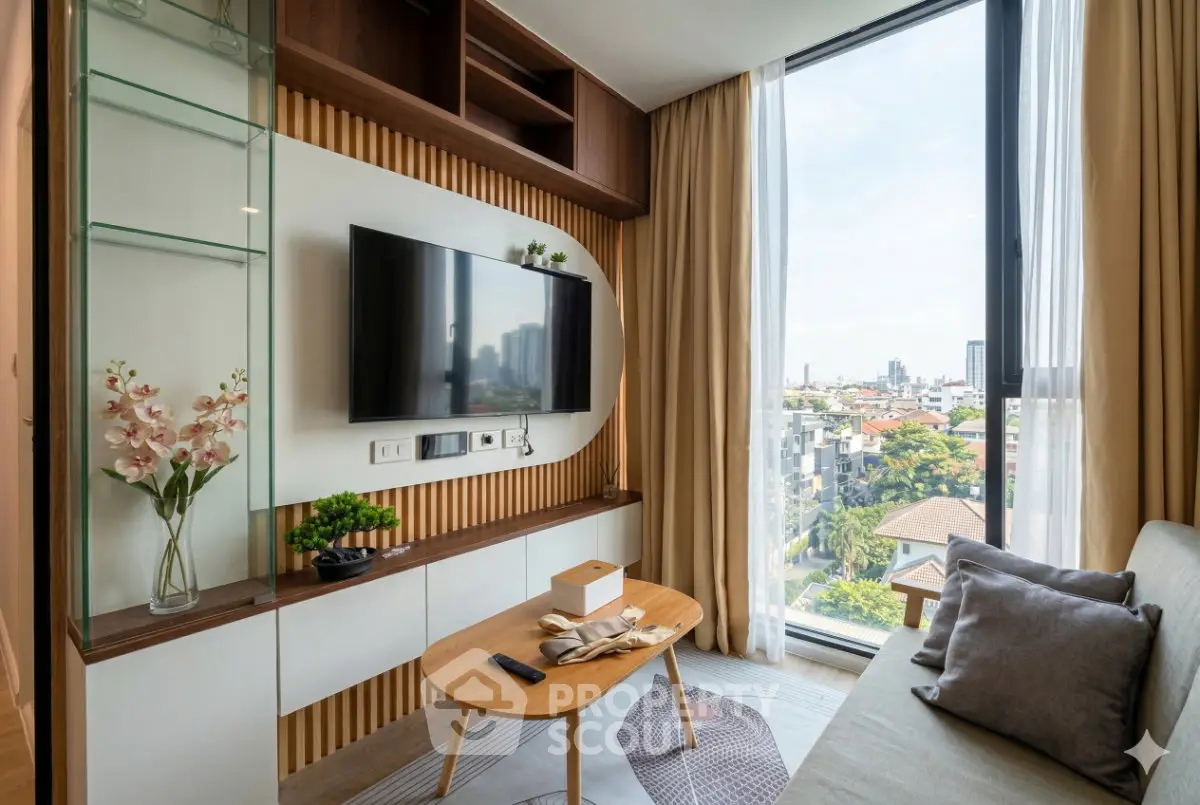 Modern living room with large window and city view, featuring stylish decor and comfortable seating.