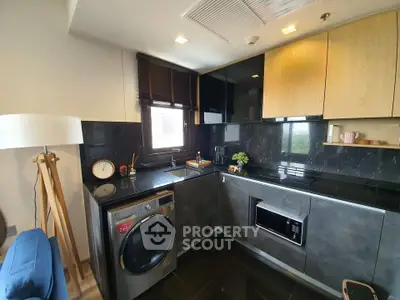 Modern kitchen with sleek black countertops, built-in appliances, and stylish cabinetry.