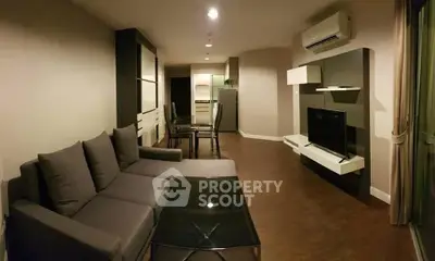 Modern living room with sleek furniture and open kitchen layout in a stylish apartment.