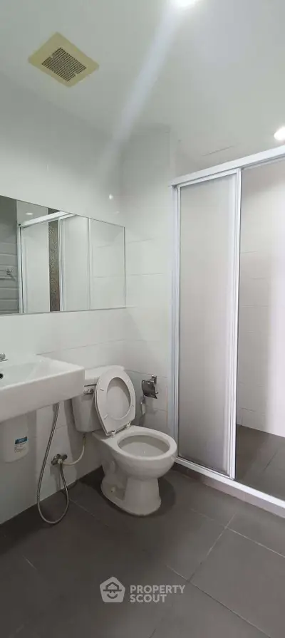 Modern bathroom with sleek design and shower enclosure in a contemporary apartment.