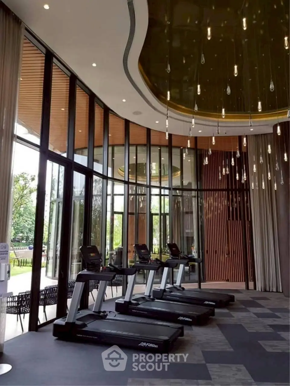 Luxurious gym with modern treadmills and elegant lighting in a high-end real estate property.
