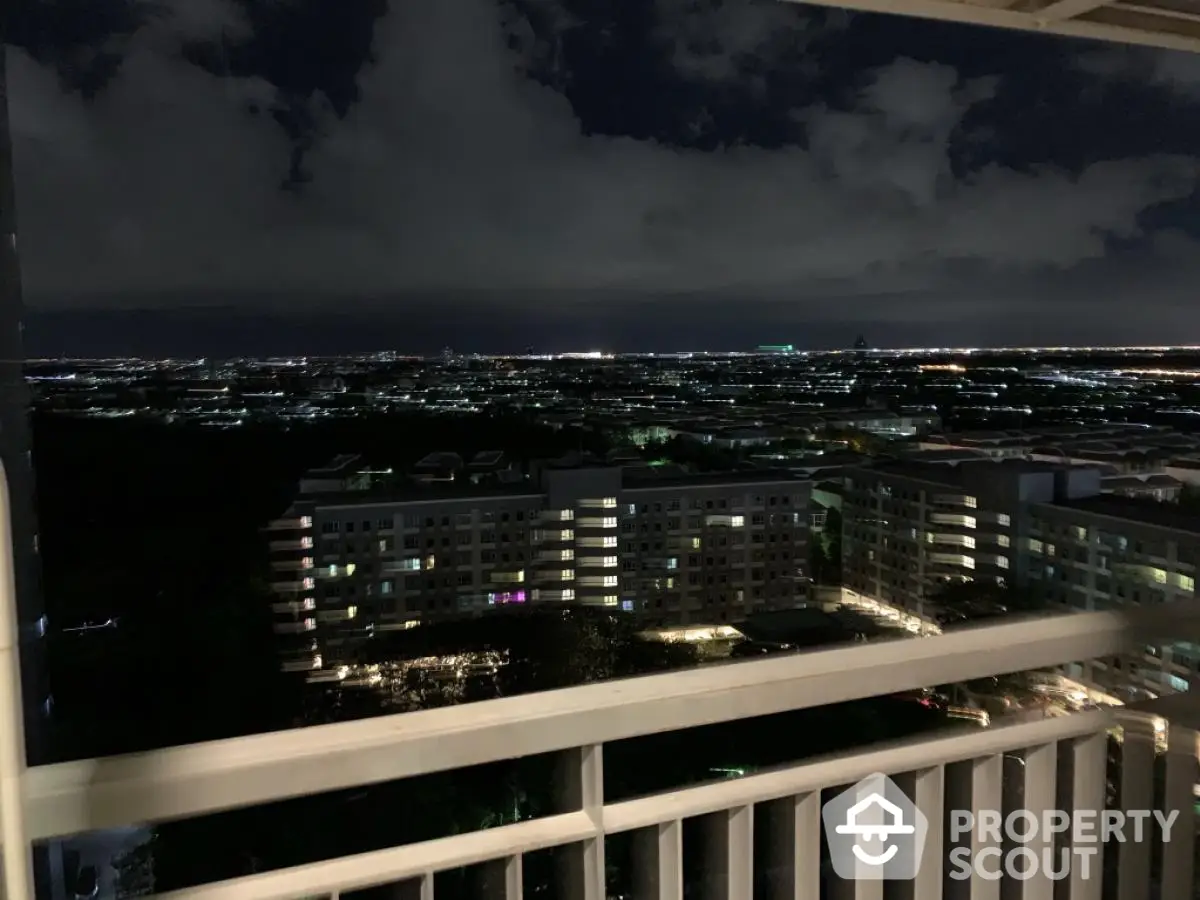 Stunning night cityscape view from high-rise balcony overlooking urban skyline.