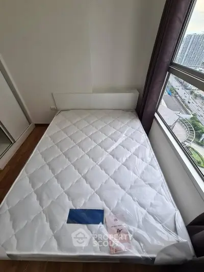 Modern bedroom with new mattress and city view from large window