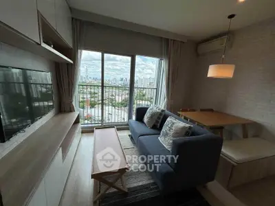 Chic living room with city view, modern furniture, and cozy ambiance in urban apartment.