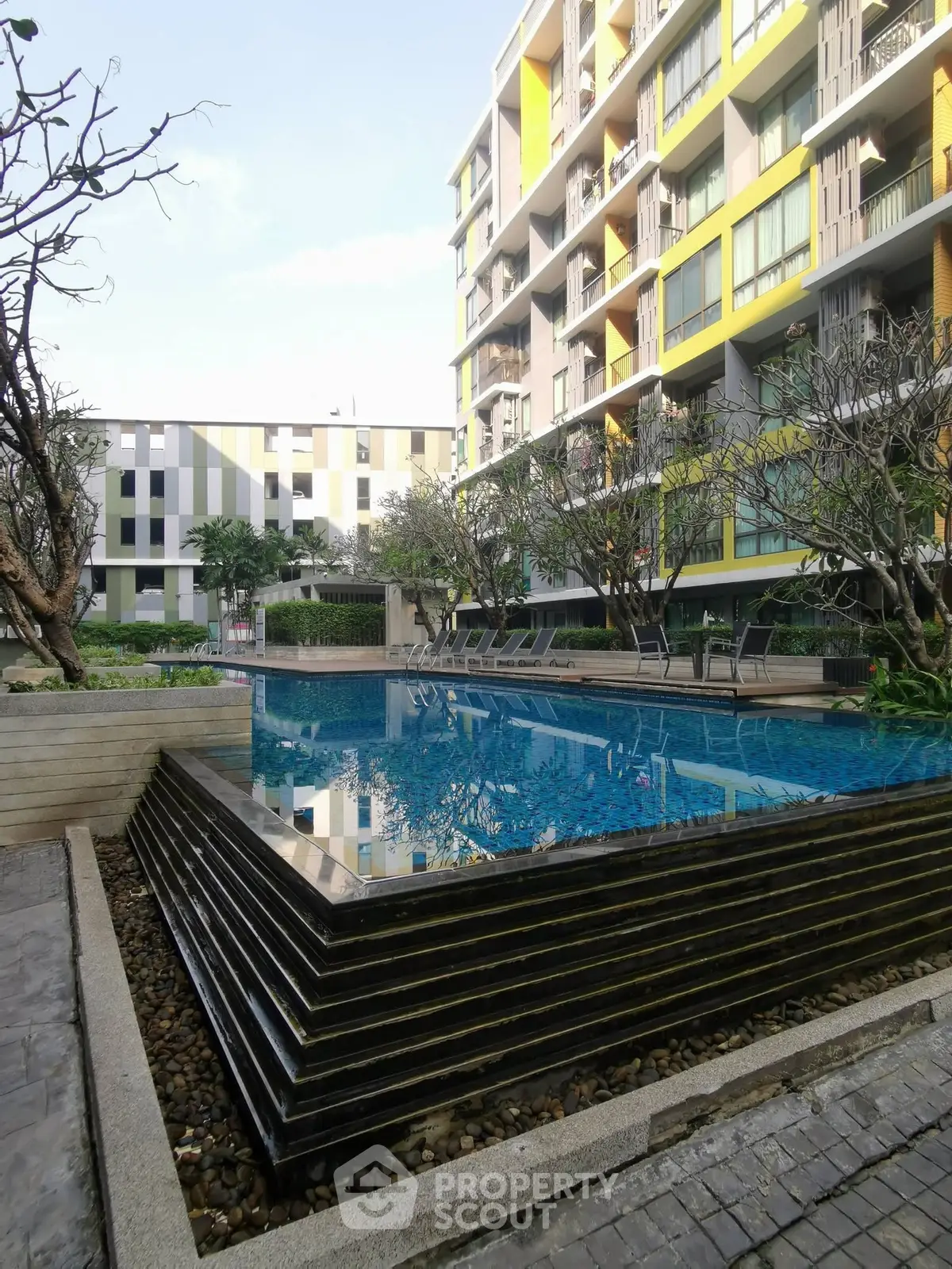 Modern apartment complex with a stunning outdoor pool and landscaped surroundings.