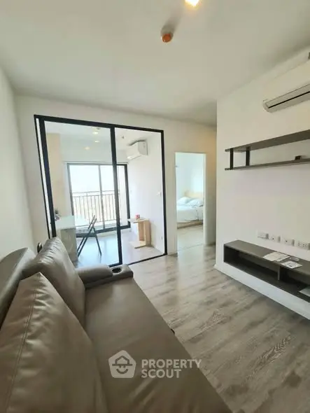 Modern living room with sleek design and balcony view in a stylish apartment.