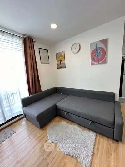 Modern living room with stylish gray sectional sofa and elegant decor, featuring wooden flooring and natural light.