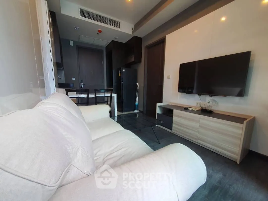 Modern living room with sleek furniture and wall-mounted TV in a stylish apartment.