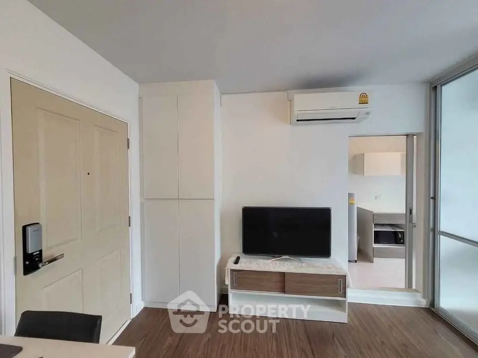 Modern living room with sleek TV setup and air conditioning in a stylish apartment.