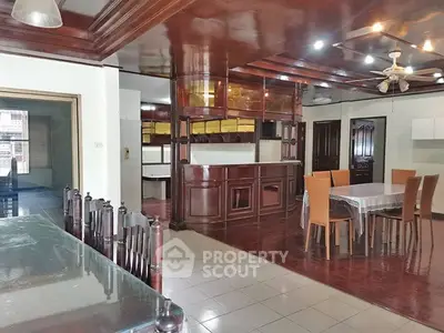 Spacious open-plan living and dining area with wooden accents and ceiling fan.