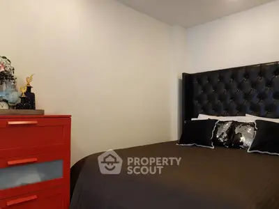 Stylish bedroom with elegant black headboard and vibrant red dresser