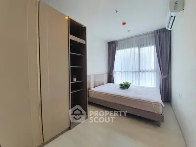 Modern bedroom with large window and stylish wardrobe in a bright apartment.