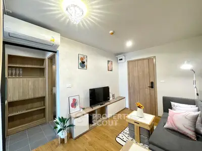 Modern living room with stylish decor and wooden flooring, featuring a cozy sofa and wall-mounted TV.